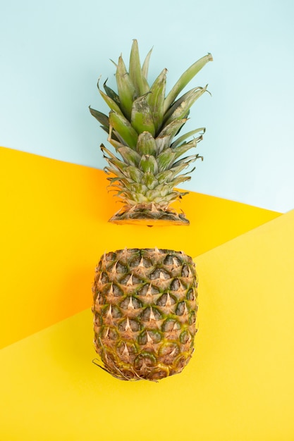 Cut pineapple mellow juicy on the ice-blue and yellow desk