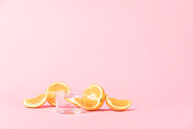 Cut slices of orange fruit on pink background