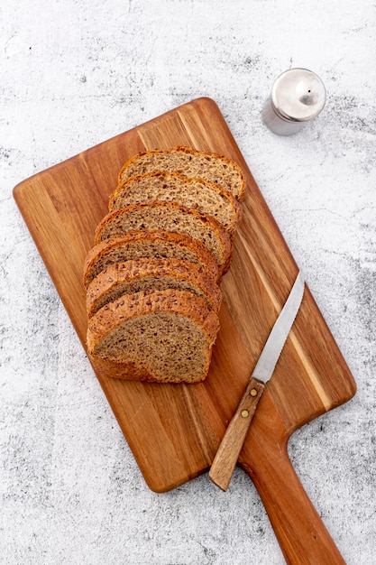 Cut slices of wholemeal bread on wooden board