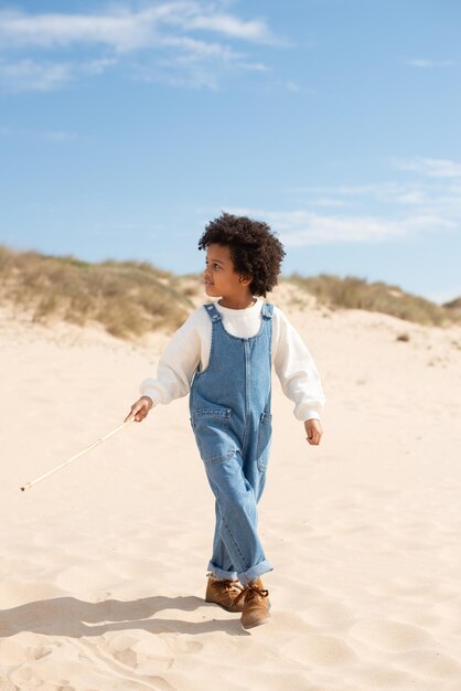 해변에서 걷는 귀여운 아프리카계 미국인 소녀