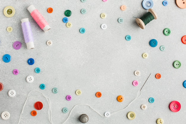 Cute arrangement with sewing threads and colourful buttons top view