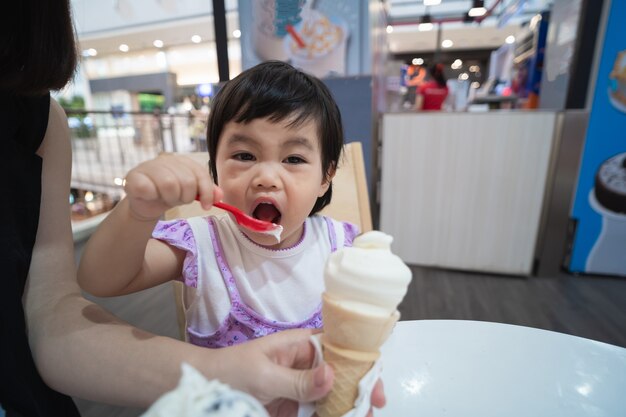 アイスクリームを食べて幸せな赤ちゃん女の子 無料の写真