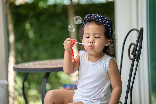 シャボン玉を吹くかわいいアジアの女児