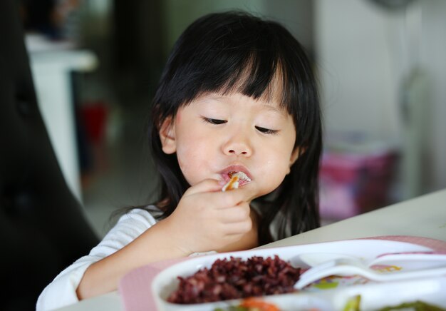 ダイニングルームでスパゲッティを食べるかわいいアジアの赤ちゃん プレミアム写真