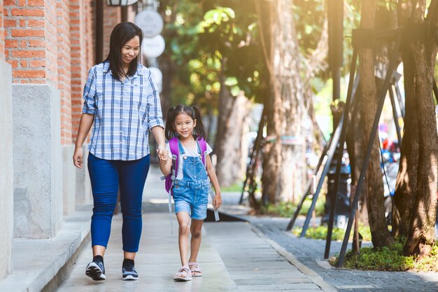Premium Photo | Cute asian pupil girl with backpack hugging her mother with  happiness after back from school