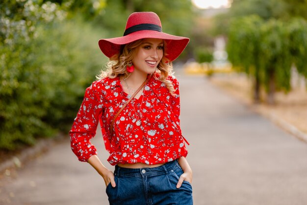 Cute attractive stylish blond smiling woman in straw red hat and blouse summer fashion outfit