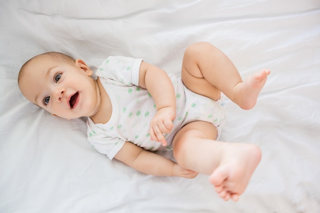 Cute baby boy relaxing on bed