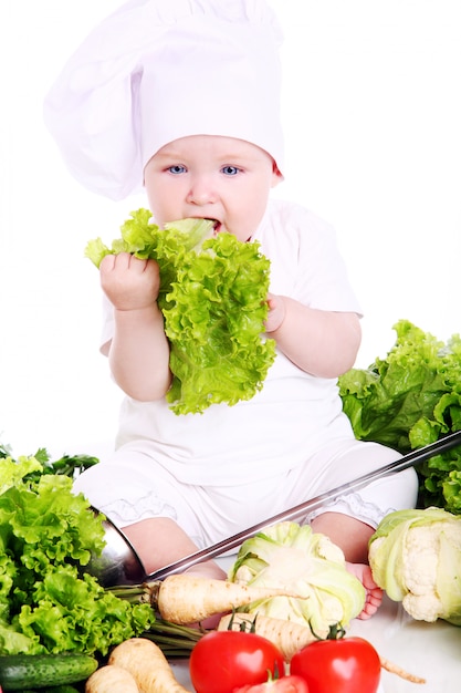 Free photo cute baby chef with vegetables