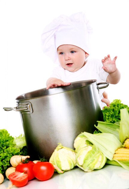 Cute baby chef with vegetables