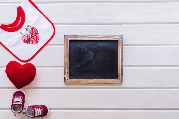 Foto gratuita concetto di bambino carino con ardesia sulla superficie di legno