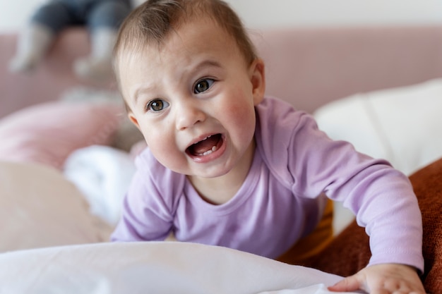 Cute baby crawling on the bed and crying