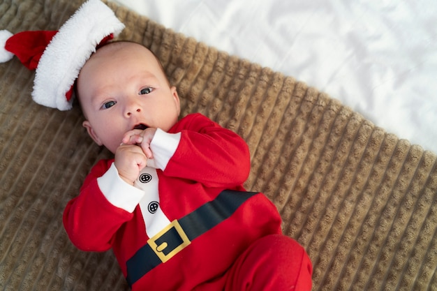 Free photo cute baby dressed in santa claus clothing