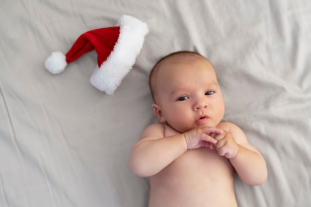 Free photo cute baby dressed in santa claus clothing