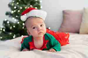 Free photo cute baby dressed in santa claus clothing