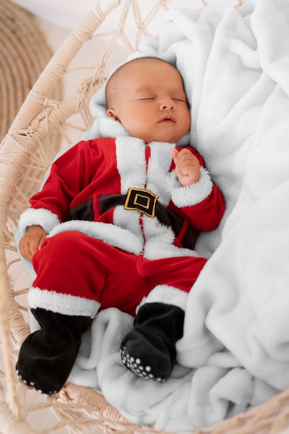 Free photo cute baby dressed in santa claus clothing