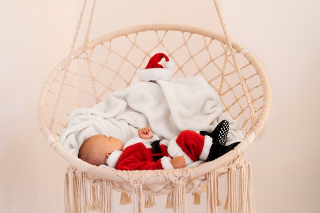 Free photo cute baby dressed in santa claus clothing