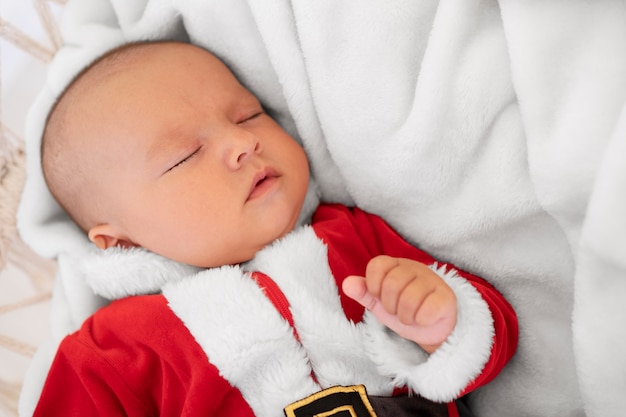 Free photo cute baby dressed in santa claus clothing