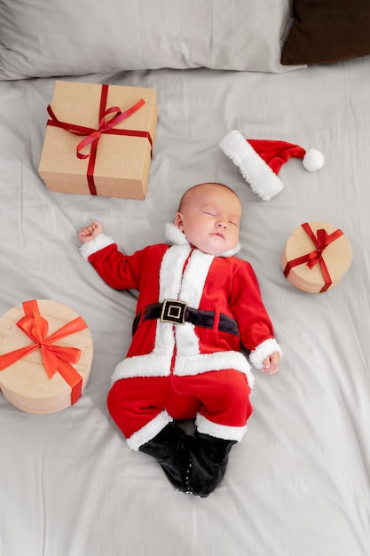 Free photo cute baby dressed in santa claus clothing