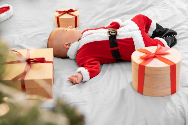 Free photo cute baby dressed in santa claus clothing