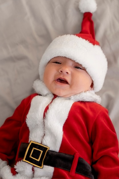 Free photo cute baby dressed in santa claus clothing