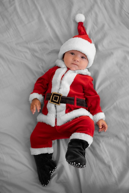 Free photo cute baby dressed in santa claus clothing