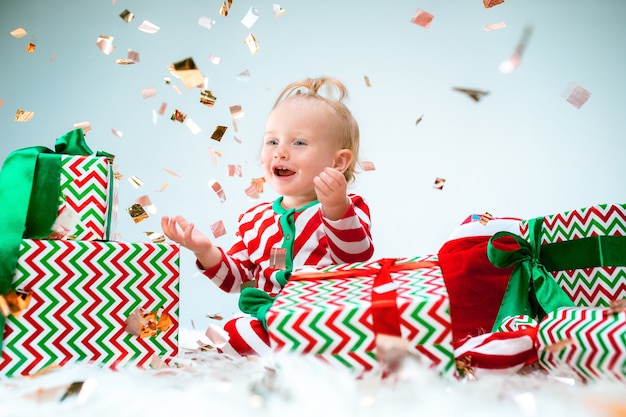 クリスマスにポーズをとってサンタの帽子の近くに1歳のかわいい女の赤ちゃん