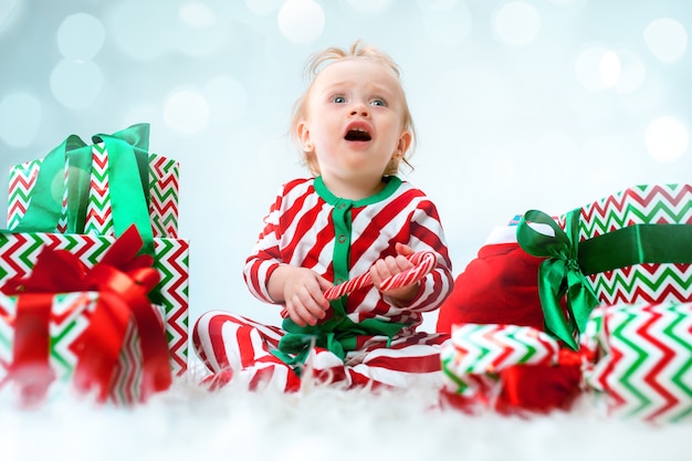 크리스마스에 포즈를 취하는 산타 모자 근처 1 살 귀여운 아기 소녀