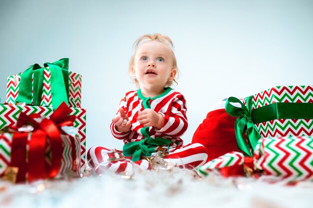 Cute baby girl 1 year old near santa hat posing over Christmas