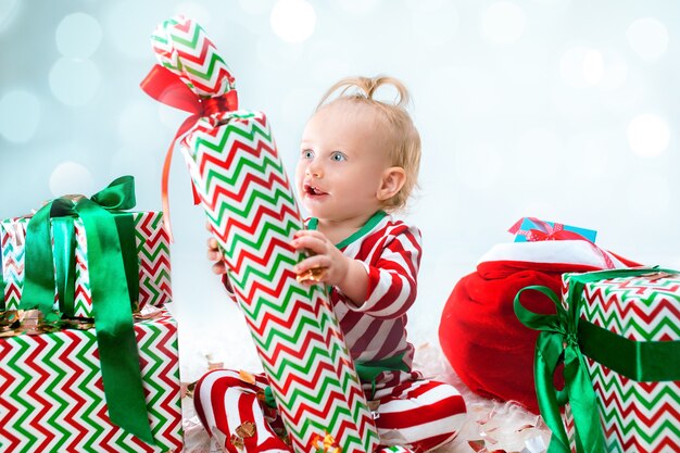 Cute baby girl 1 year old near santa hat posing over Christmas