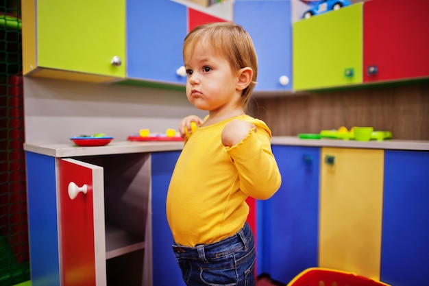 Cute baby girl playing in indoor play center Kindergarten or preschool play room In the children's kitchen