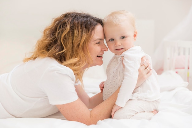 Cute baby girl playing with mother at home