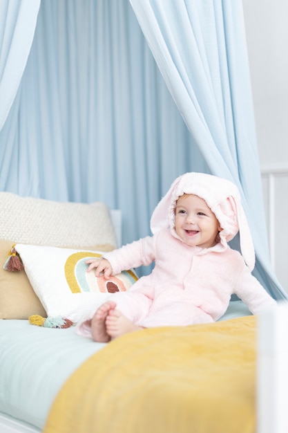 Free photo cute baby girl sitting on her bed