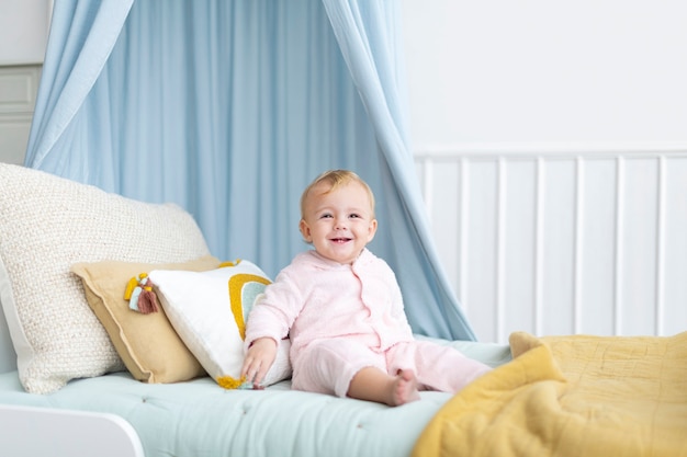 Free photo cute baby girl sitting on her bed