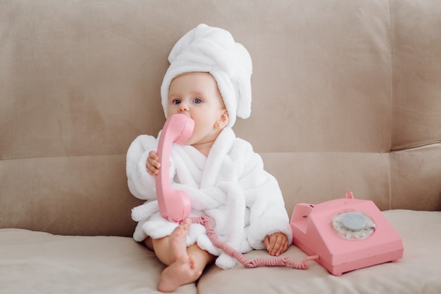 Cute baby girl in white bathrobe