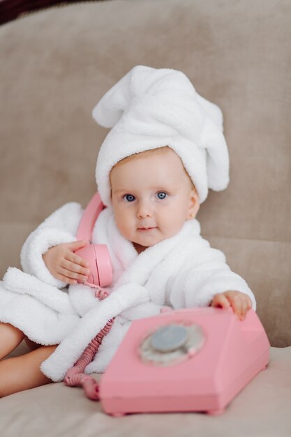 Cute baby girl in white bathrobe