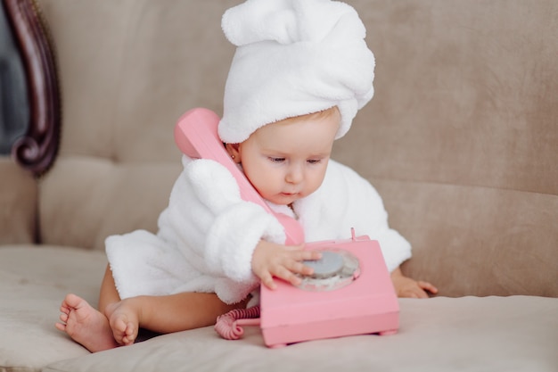 Cute baby girl in white bathrobe