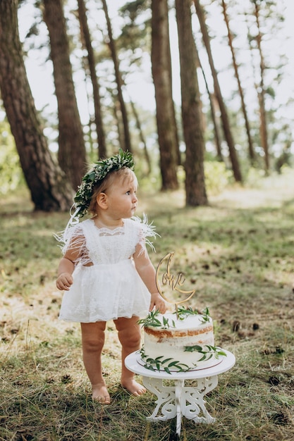 Cute baby girl with her first birthday cake