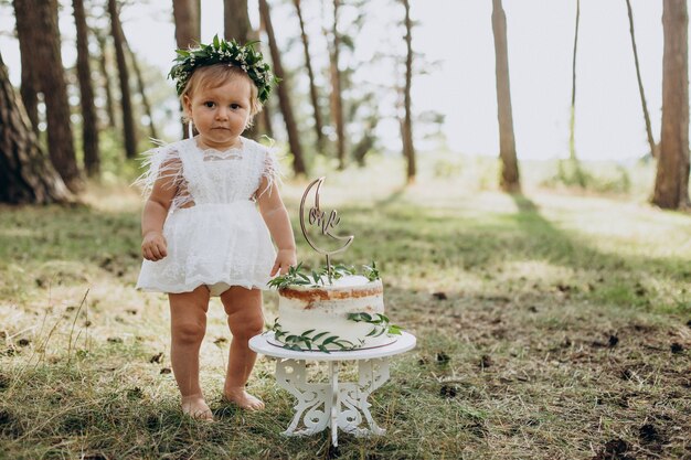 Cute baby girl with her first birthday cake