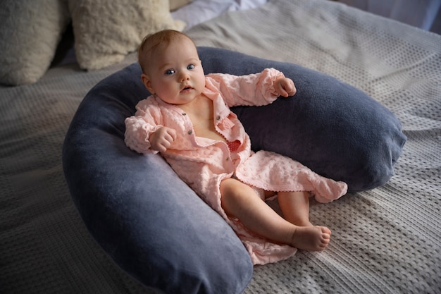 Free photo cute baby on nursing pillow