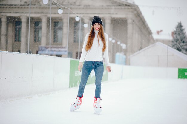 Милая и красивая девушка в белом свитере в зимнем городе