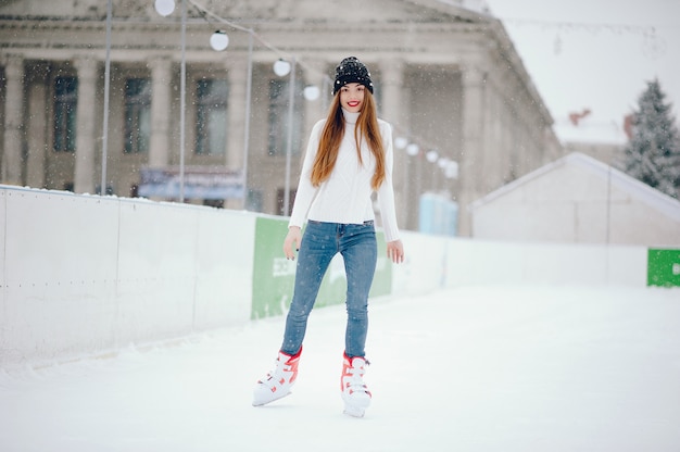 Cute and beautiful girl in a white sweater in a winter city