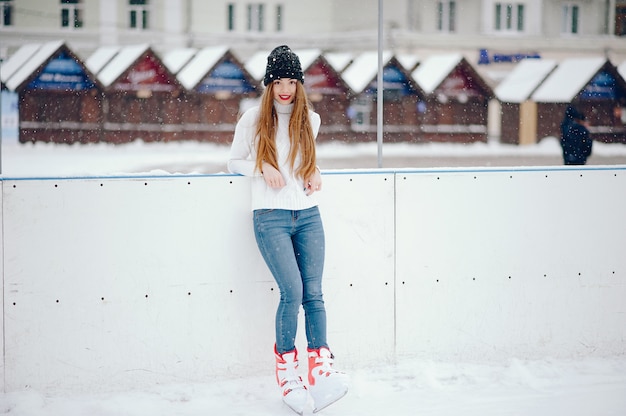 Free photo cute and beautiful girl in a white sweater in a winter city