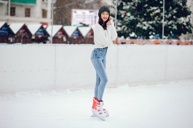 Cute and beautiful girl in a white sweater in a winter city