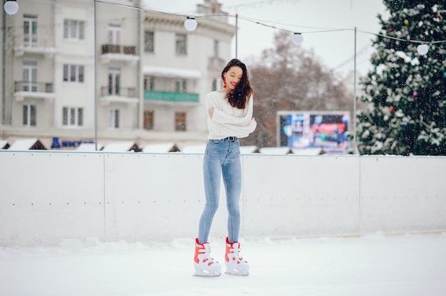 겨울 도시에서 하얀 스웨터에 귀엽고 아름다운 소녀