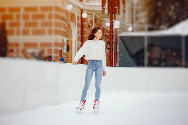 Free photo cute and beautiful girl in a white sweater in a winter city