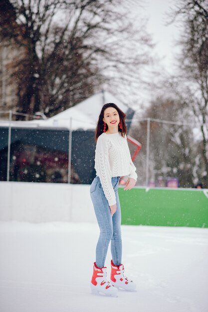 冬の街で白いセーターでキュートで美しい少女