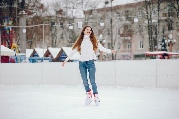 겨울 도시에서 하얀 스웨터에 귀엽고 아름다운 소녀