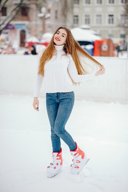 冬の街で白いセーターでキュートで美しい少女