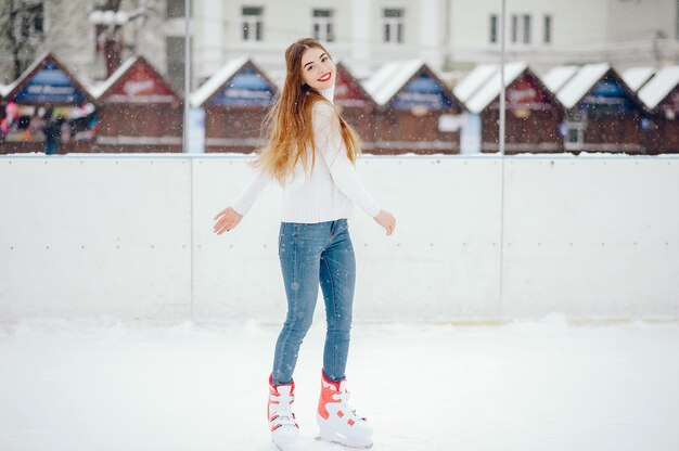 Cute and beautiful girl in a white sweater in a winter city