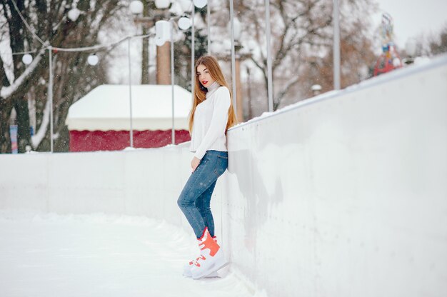 Cute and beautiful girl in a white sweater in a winter city